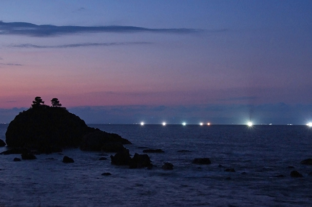夜の海に灯る漁火